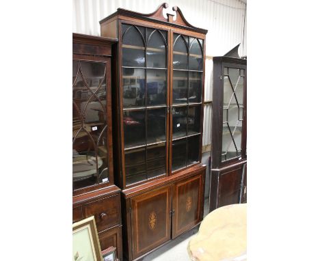 George III style Mahogany Inlaid and Crossbanded Bookcase, the tall upper section with a swan neck pediment and two glazed do