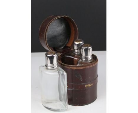 Set of Three Glass Curved Glass Spirit Bottles contained in an Italian Leather Circular Case marked Gin, Whisky and Cognac, 1