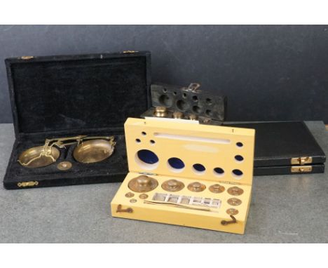 Two cased sets of brass scales together with two cased sets of brass weights. 