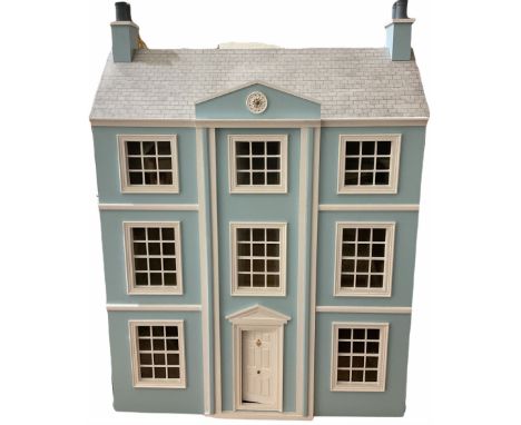 Georgian style wooden double fronted three-storey dolls house with pale blue stucco finish under a faux tiled roof with two c