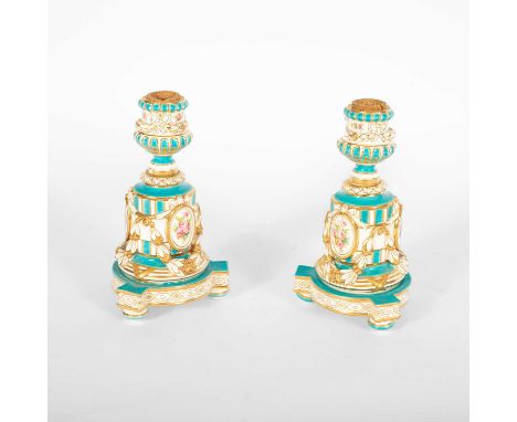 A pair of Minton candlesticks, 19th Century, the cylindrical gadrooned column stems applied panels of pink roses between heav