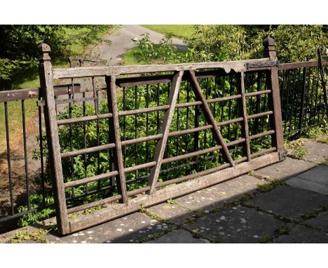An early 20th Century oak gate, the bars joined by a central A frame, with metal latch and hinge, hinge marked Quincey, Apeth