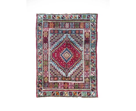 A Rabat rug, Morocco, circa 1920, the abrashed blue field centred by an aubergine stepped medallion, with arrow motif spandre