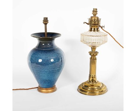 An early 20th Century brass and clear glass oil lamp, 50cm high and a blue ceramic vase turned table lamp, 44cm high (2)