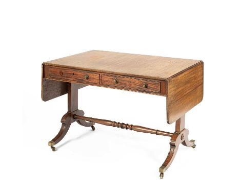 A Regency mahogany sofa table the rectangular top with two drop leaves, with two frieze drawers opposing dummy drawers, on ta