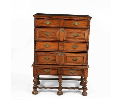 A 17th Century fruit wood chest of four drawers on an associated stand with single drawer, the turned legs united by flat wav