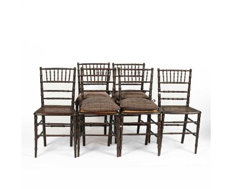 A set of six Regency style black painted faux bamboo chairs each with a caned seat and later tie on cushion, 81cm high, seat 