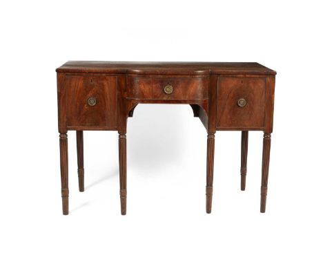 A late Georgian mahogany breakfront sideboard, with central drawer flanked by deep drawers, on turned legs with reeded fronts