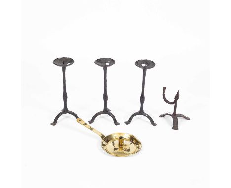 Three iron pricket candlesticks on tripod bases, 33cm high, an iron rushlight holder on a tripod base, 19cm high and a brass 