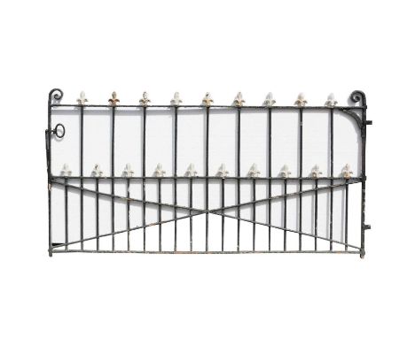 A 19th Century wrought iron gate, the vertical bars with fleur-de-lys finials, 244cm wide (including hinge) x 128cm high