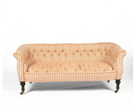 A Victorian Chesterfield sofa, the curved button back and seat on turned and ebonised legs with brass and ceramic castors, 17