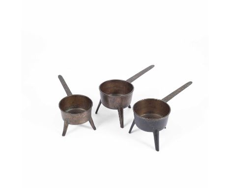 Two lead bronze skillets on tripod feet, the handle cast 'Cox. Taunton. IV', and another cast 'T. Blinman &amp; Co. III', 40c