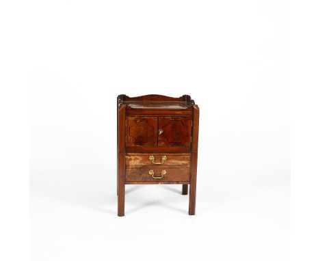 A George III style mahogany bedside commod the rectangular galleried top with pierced handles, above cabinet doors, a commode