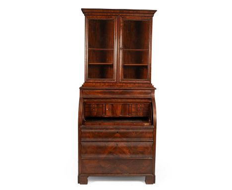 A North European mahogany rolltop bureau bookcase the glazed upper section enclosing three adjustable shelves, the bureau wit