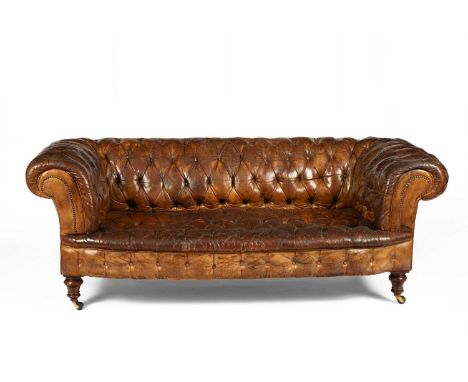 A button back brown leather Chesterfield sofa, early 20th Century, on turned supports and castors, 203cm wide, 87cm deep, 73c