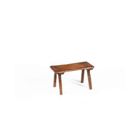 A 19th Century pine milking stool, the rectangular top on four plain legs, 51cm wide, 22cm deep, 29cm high