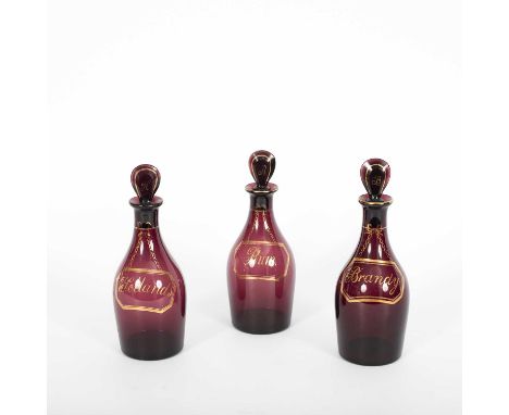 Three amethyst glass decanters and stoppers, named in gilt Brandy, Hollands &amp; Rura, 22cm highIn good condition - without 