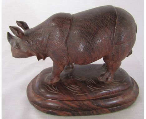 Carved rosewood model of a rhinoceros naturalistically modelled, standing on a domed plinth base L 17 cm