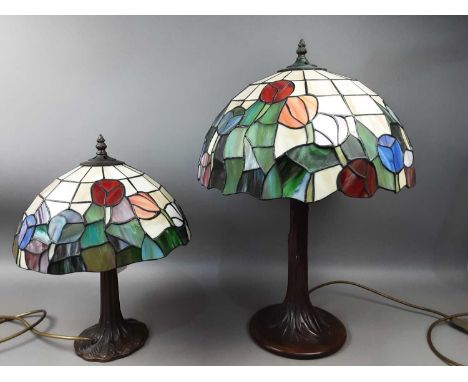 TWO TIFFANY STYLE TABLE LAMPS,with leaded shades, both on trunk bases, the larger 56cm high (2)