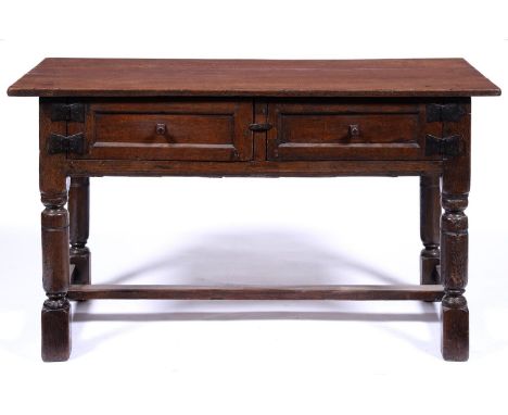 A 17th c style oak hutch, late 19th c, the over-sailing rectangular top above a pair of panelled rectangular doors with bold 