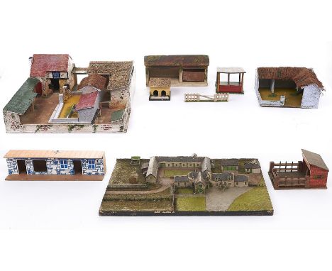 A collection of model farm and other buildings, c1930-50's, painted wood, two with thatched roof and a Tiger Toys building, v