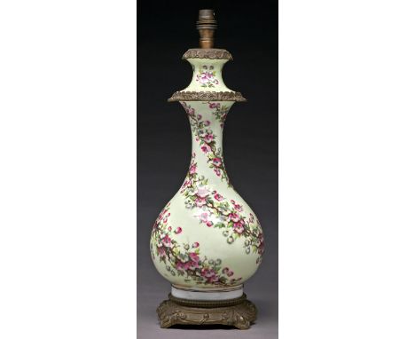 A French gilt lacquered brass mounted porcelain oil lamp, c1880, of baluster shape, painted with spiralling blossom on a pale