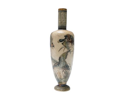 The cylindrical form rises from a flared foot to a tall geometric-decorated neck. The body is incised with a detailed natural