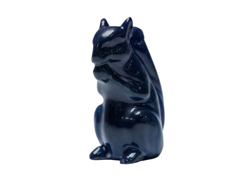 This ceramic figure depicts a squirrel seated upright with a nut held in its mouth. Finished in a rare blue experimental glaz