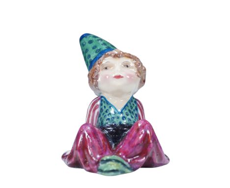 This seated figure is dressed in a pointed green and blue polka-dot hat, a matching vest with red and white striped sleeves, 