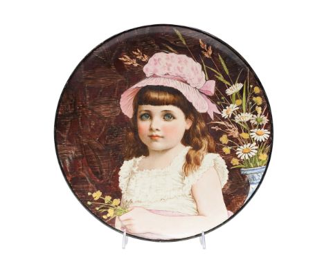 Featuring a printed and enamel-painted depiction of a young girl with blue eyes and long brown hair. The girl is shown wearin