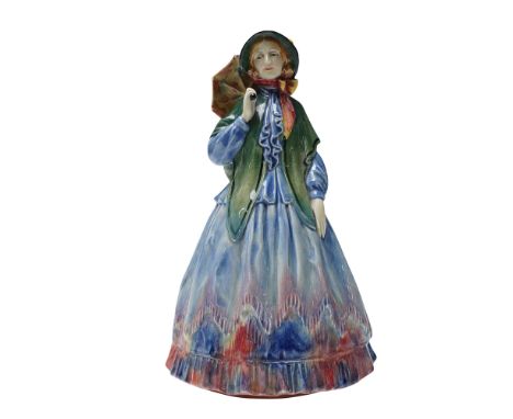 The figure is portrayed in a full-length dress composed of a blue bodice and red skirt, accented with a green shawl draped ov
