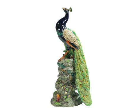 Part of the Minton in Miniature series. This piece depicts a peacock perched atop a rock formation, featuring detailed modeli
