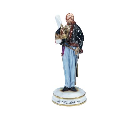The figure is presented in full uniform, including red tunic, blue trousers, and a fur-trimmed pelisse, with a busby under th