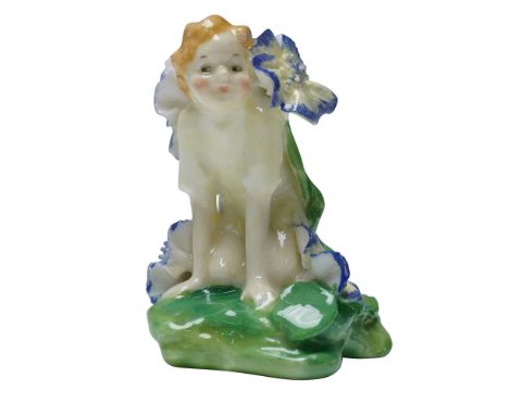 The figure depicts a crouching child-like fairy surrounded by blue-edged floral blooms on a green base. The model is marked w
