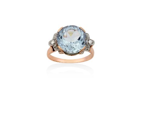 An Aquamarine and Diamond Ringthe round cut aquamarine in yellow claw settings, flanked by eight-cut diamonds, to a tapered s