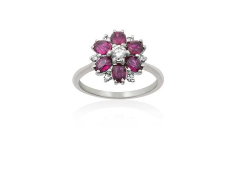 A Pinkish-Red Stone and Diamond Cluster Ringthe round brilliant cut diamond within a border of oval cut pinkish-red stones, s