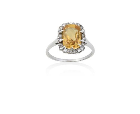 A Yellow Sapphire and Diamond Cluster Ringthe rectangular cushion cut yellow sapphire within a border of eight-cut diamonds, 