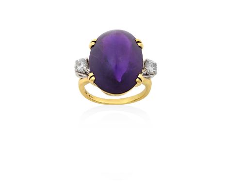 An Amethyst and Diamond Three Stone Ringthe oval sugarloaf cabochon amethyst in a yellow claw setting, flanked by round brill