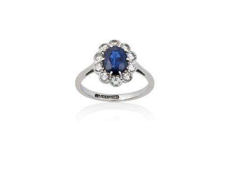 A Sapphire and Diamond Cluster Ringthe oval cut sapphire within a border of round brilliant cut diamonds, in white claw and r