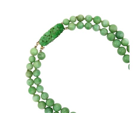 A Jade Two Row Necklacethe 46:51 graduated jade beads knotted to clasp formed of a carved and pierced rectangular plaque depi