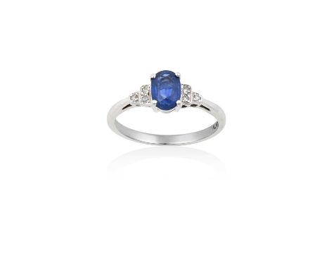 A Sapphire and Diamond Ringthe oval cut sapphire in a white four claw setting, to stepped eight-cut diamond set shoulders, on