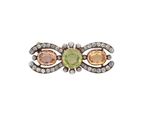 A Late 19th Century Peridot, Topaz and Diamond Broochthe round cut peridot flanked by oval cut topaz within scroll borders of