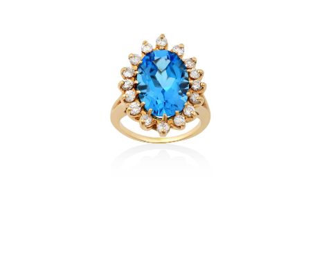 A Blue Topaz and Diamond Cluster Ringthe oval blue topaz within a border of round brilliant cut diamonds, in yellow claw sett