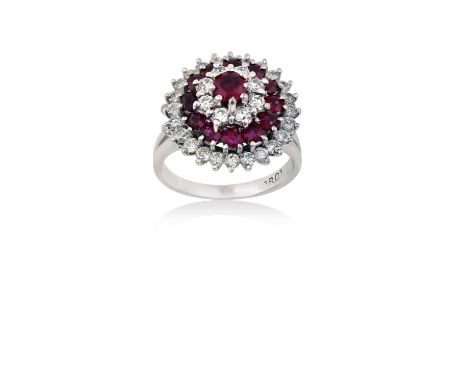 A Ruby and Diamond Cluster Ringthe central raised ruby within a triple stepped border of round brilliant cut diamonds alterna