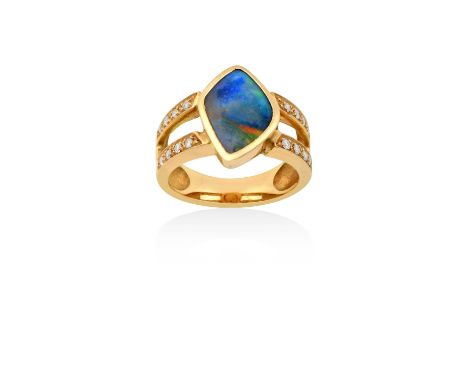 A Composite Opal and Diamond Ringthe irregular shaped composite opal in a yellow rubbed over setting, to two rows set through