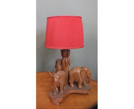 A 1960's carved wooden table lamp with three elephants to base