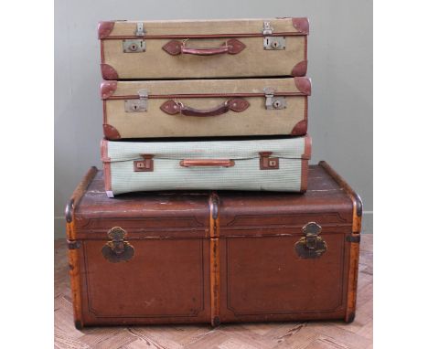 A large steamer trunk and three canvas and leather suitcases