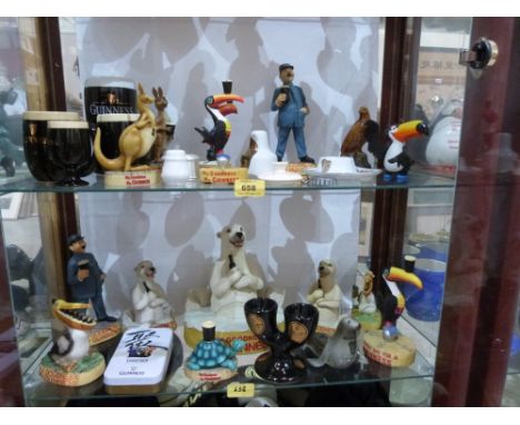 A collection of Guinness themed resinous and ceramic figures and objects to include some Carlton Ware; together with Guinness