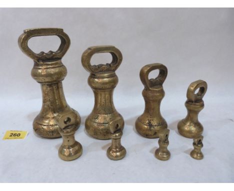 A set of eight brass scale weights