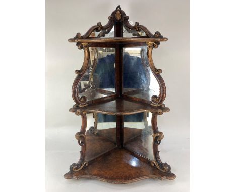 A 19th century walnut corner shelf, with mirror back (one piece cracked) and gilt scrolling form, with three graduated shelve